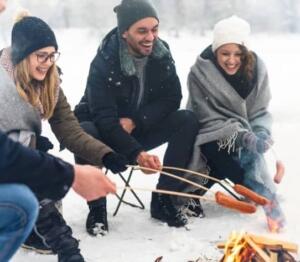 Mensen barbecueën in sneeuw.